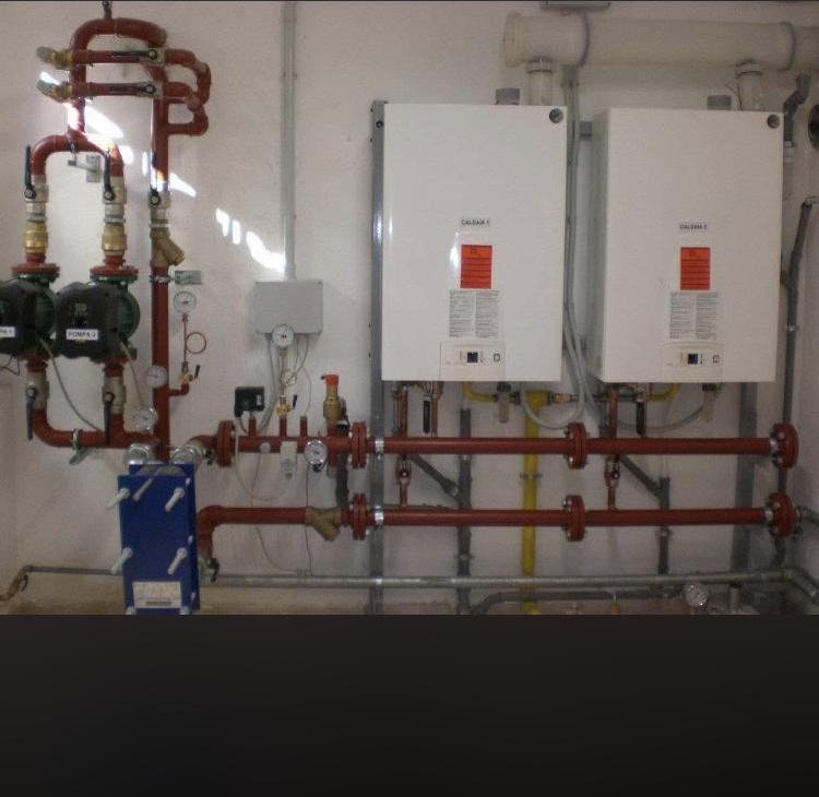 Centrale termica con collettori rossi, circolatori e scambiatore a piastre