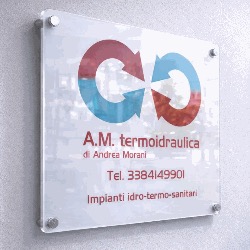 L'insegna di A.M. termoidraulica: il marchio a due archi, rosso e blu, sopra il nome dell'azienda